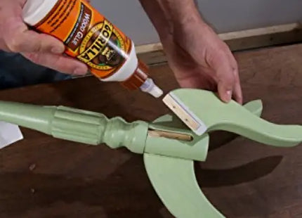 a man is using a glue to fix a table