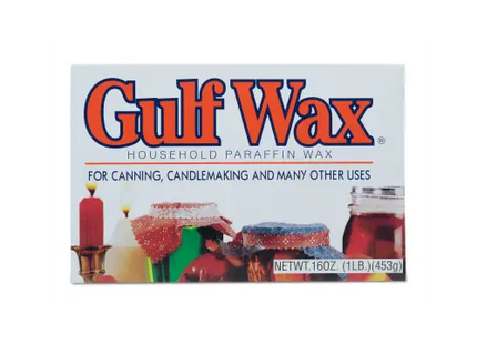 a close up of a box of glue wax with a candle