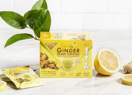 a close up of a box of ginger honey crataes next to lemons