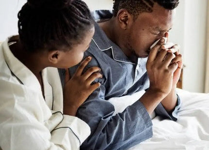 a man and woman sitting on a bed